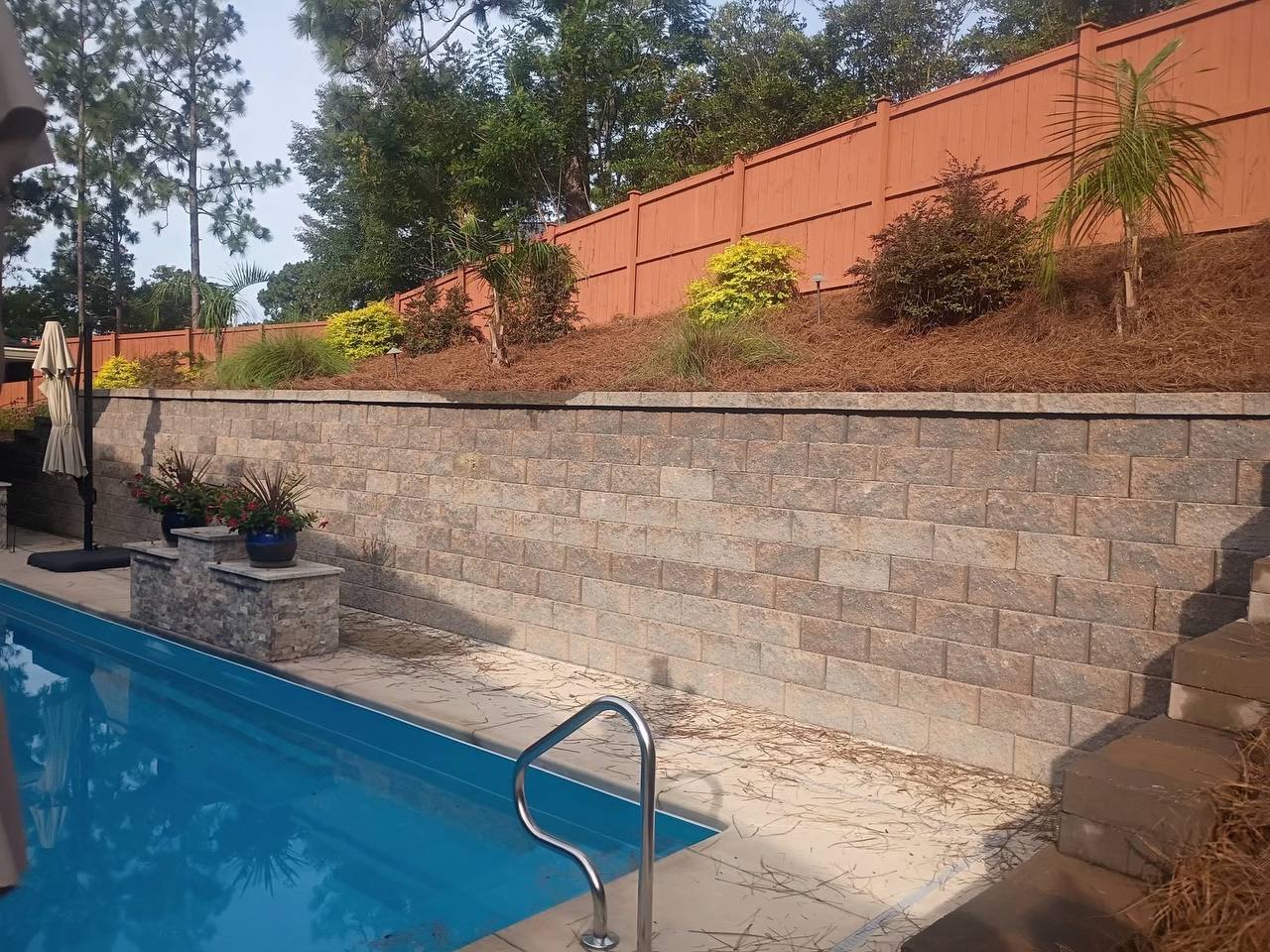 Poolside landscape bed with retaining wall